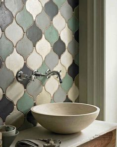 a white bowl sitting on top of a counter next to a sink in front of a window