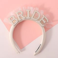 a bridal headband with pearls and tulle on top of a pink background