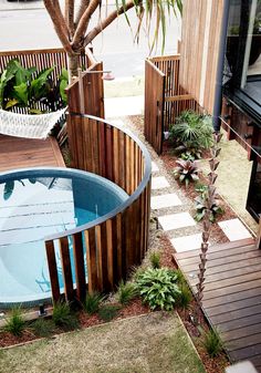 an outdoor hot tub in the middle of a yard with wooden steps leading up to it