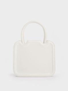 In classic white to match most outfits you can put together, the Perline sculptural tote bag is a worthy addition to your list of style staples. Featuring a square silhouette with rounded corners for a more feminine feel, the details make all the difference when it comes to this piece – the semicircle cut outs and gold-toned brand insignia add a touch of sophistication. Carry yours by the handles for a polished and sophisticated feel, or clip on the adjustable strap to create a cool and casual a Modern Rectangular Recyclable Bag, Trendy White Square Box Bag, Trendy White Box Bag For Daily Use, Casual White Box Bag With Removable Pouch, Eco-friendly White Bags For Everyday, Casual White Box Shoulder Bag, White Tote Shoulder Bag With Adjustable Handle, White Box Bag For Spring Shopping, White Box Bag For Shopping In Spring