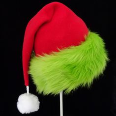 "This festive Santa hat is made up in a red fleece fabric and features an accent brim of lush bright green fur trim, close match to a Grinch green. The red fabric is a soft quality poly fleece fabric, cozy and warm. Proportions of the hat are generous and will fit most head sizes, ladies or gents. The styling is a slouch cone, traditional Santa look. Measurement for opening for your head is 24- 25\" circumference and the length is 20\". There is a white faux fur pompom dangle on the hat." Green Winter Costume Hats And Headpieces, Green Brimmed Winter Costume Hats, Grinch Hat, Christmas Party Hat, Christmas Party Hats, Green Santa, Green Fur, Santa Claus Hat, Elf Hat