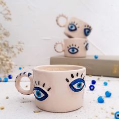 two coffee mugs with blue eyes on them