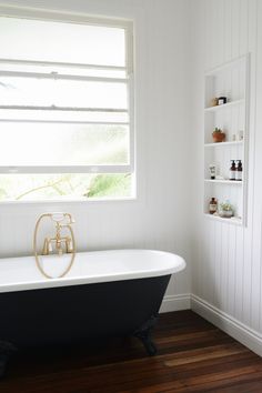 a white and black bath tub sitting next to a window