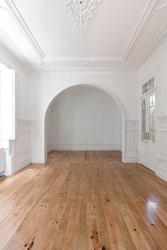 an empty room with white walls and wood floors