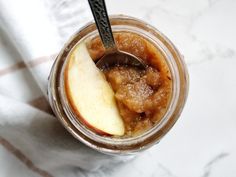 an apple pie in a jar with a spoon