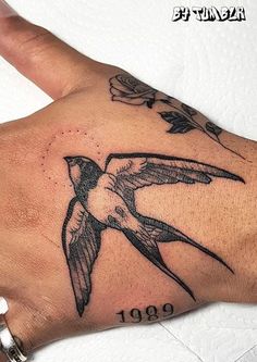 a hand with a hummingbird tattoo on it's left arm and the number 1909 written in black ink