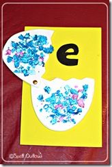 the letter e is made up of blue and pink sprinkles on a yellow background