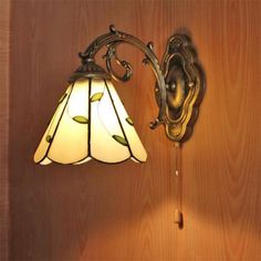 a lamp that is on the wall next to a light fixture and wood paneled walls