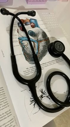 a stethoscope laying on top of an open book with drawings and illustrations