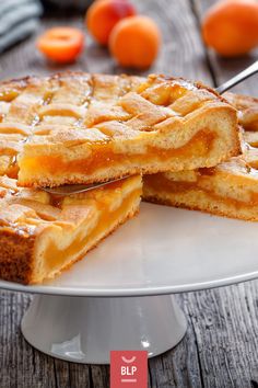 two pieces of pie on a white plate with oranges in the backgroud