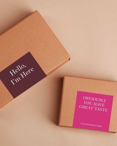 two brown boxes with pink labels on them sitting next to each other, one is open and the other has a label that says hello i'm here