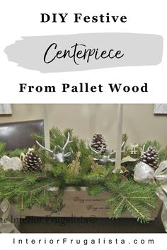 the centerpiece from pallet wood is decorated with pine cones and white flowers