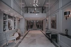 an elegant hallway with chandeliers and white furniture