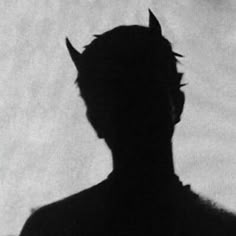 the silhouette of a man with horns on his head