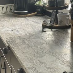 a kitchen counter with coffee cups on it