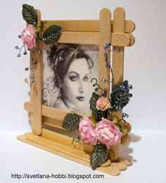 a wooden frame with flowers and leaves on the front is holding an image of a woman's face