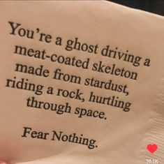 someone holding up a piece of paper that says you're a ghost driving a meat - coated skeleton made from stardust, riding a rock, hurtling through space