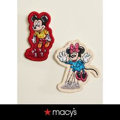 two mickey mouse patches sitting on top of a white table next to an image of the same character