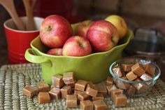 some apples are sitting in a green bowl next to other food and utensils