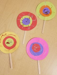 four colorful paper plates sitting on top of a wooden table