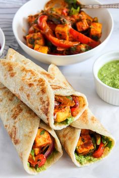 two pita breads on a plate with guacamole and salsa in the background