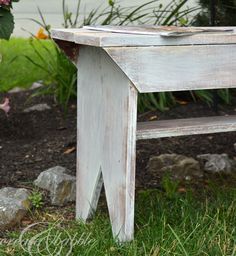 a wooden bench sitting in the grass next to a sign that says farmhouse bench diy