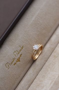 an engagement ring sits in a box on display