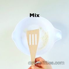 a hand holding a wooden spoon with white powder in it and the words mix above it