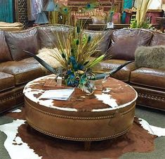 a living room filled with lots of furniture and cow hide rugs on the floor