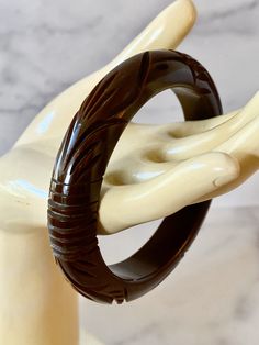 Gorgeous Foliate Carved Chocolate Bakelite Bracelet. Features a carved popular geometric pattern of circles and foliate design. The bracelet is in very good vintage condition, sold as found. Incredible statement set, true vintage. Standard 2.5 inch opening. 1/2 Inch wide width. I love mixing all the different shades of Chocolate, please be sure to see the other chocolate colored Bakelite bangles I have for sale You will not be disappointed with this beauty, it can hold its own or show up in a St Art Deco Carved Round Jewelry, Antique Carved Bracelets, Adjustable Carved Round Bracelets, Elegant Adjustable Carved Bracelet, Elegant Carved Adjustable Bracelet, Adjustable Carved Bracelets, Art Deco Bangle Bracelets Collectible, Elegant Carved Bracelet, Elegant Bakelite Bangle As A Gift