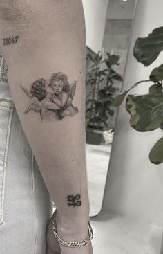 a woman's arm with an angel tattoo on it