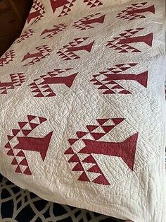 a bed with a red and white quilt on it