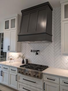 a stove top oven sitting inside of a kitchen next to white cabinets and counter tops