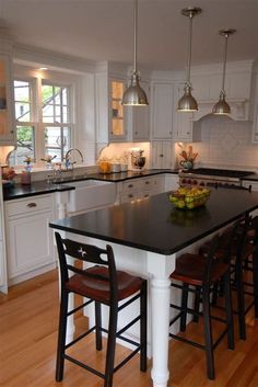 a large kitchen with an island in the middle and chairs at the counter top,