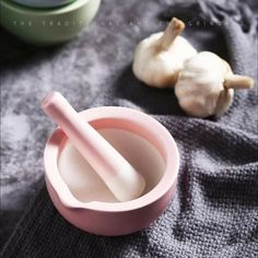 an image of garlic on the table with it's mortar and bowl next to it