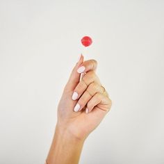 a woman's hand holding a candy lollipop