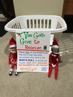 two elfs sitting in front of a sign that says you got to give to receive