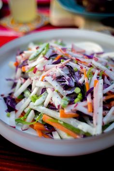 a white plate topped with lots of veggies on top of a wooden table