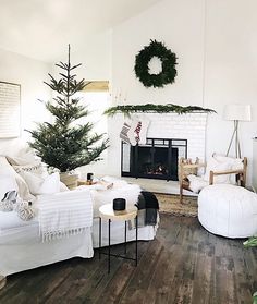 a living room filled with furniture and a fire place next to a christmas wreath on the wall