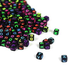 several black and multicolored dices laying on top of each other with the letters spelled out