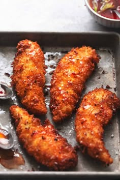 fried chicken on a baking sheet with dipping sauce