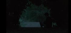 a person sitting on a bench in the dark