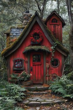 a small red house in the woods with moss growing on it's roof and windows