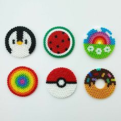 four different types of beaded magnets on a white surface, each with a colorful design