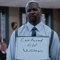 a man holding a sign with the words confused old woman written on it in front of him