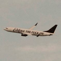 an airplane with the words move the flock on it flies through the sky in preparation for takeoff