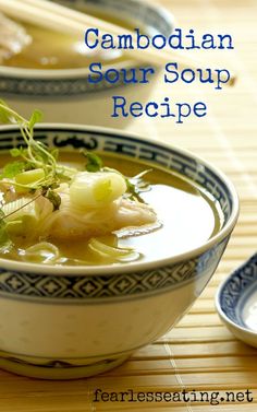 two bowls filled with soup on top of a wooden table