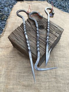 two pairs of scissors sitting on top of a piece of wood next to each other