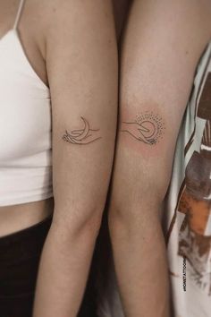 two women's arms with tattoos on them, one is holding the other arm