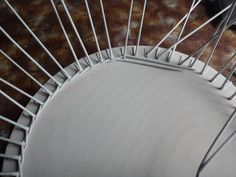 a white chair with metal bars on the back and seat, viewed from up close